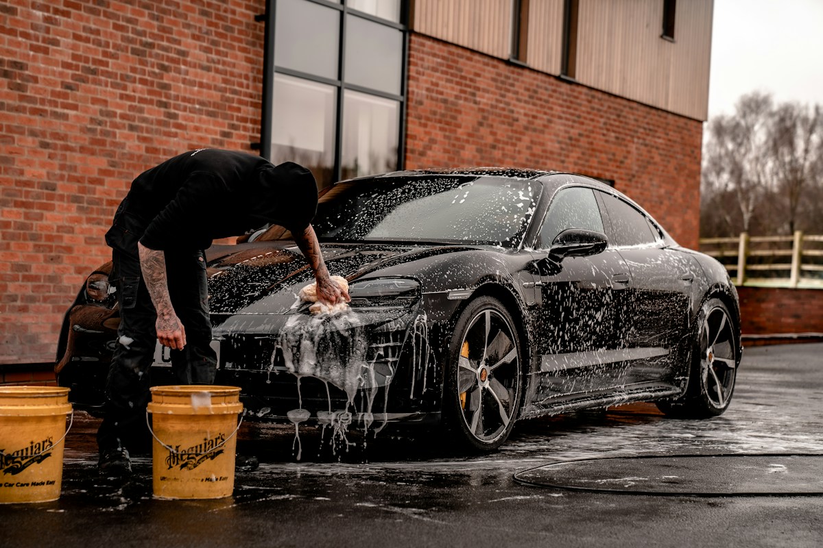 A black sports car being carefully washed by hand